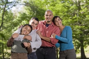 Mixed race family members hugging and smiling