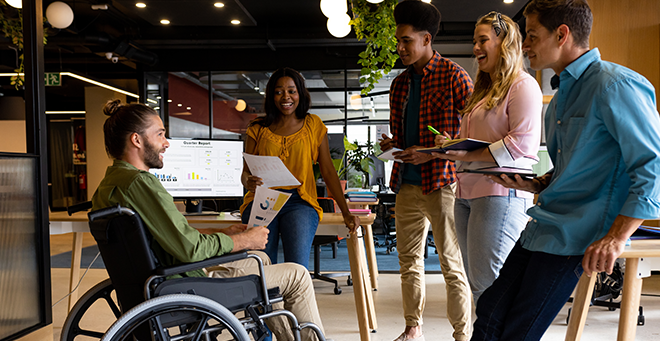 Workplace colleagues (including one with a disability) conversing. (Stock image from Shutterstock)
