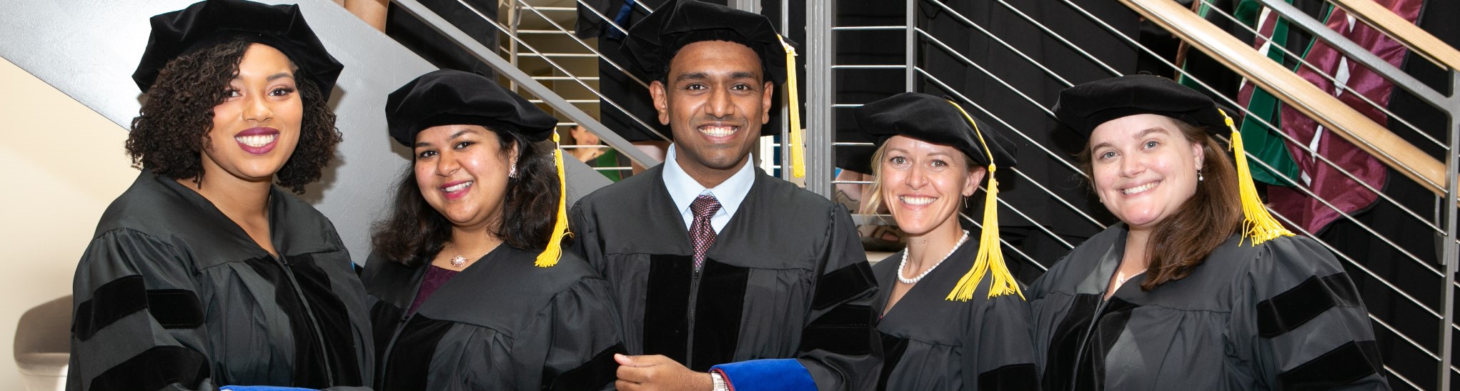 Five students in caps and gowns.
