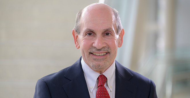 Jerry H. Gurwitz wearing a suit and tie in front of a staircase