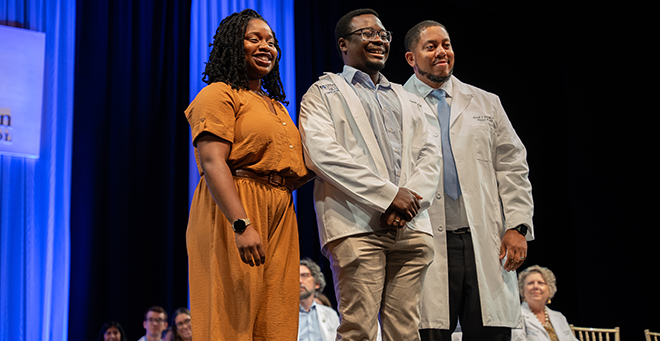 Medical student Toluwanimi Ajayi smiles after donning his white coat.
