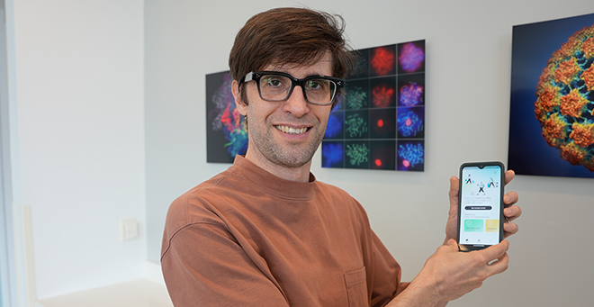 Andrés Colubri holding his cell phone with the Travel Healthy app.